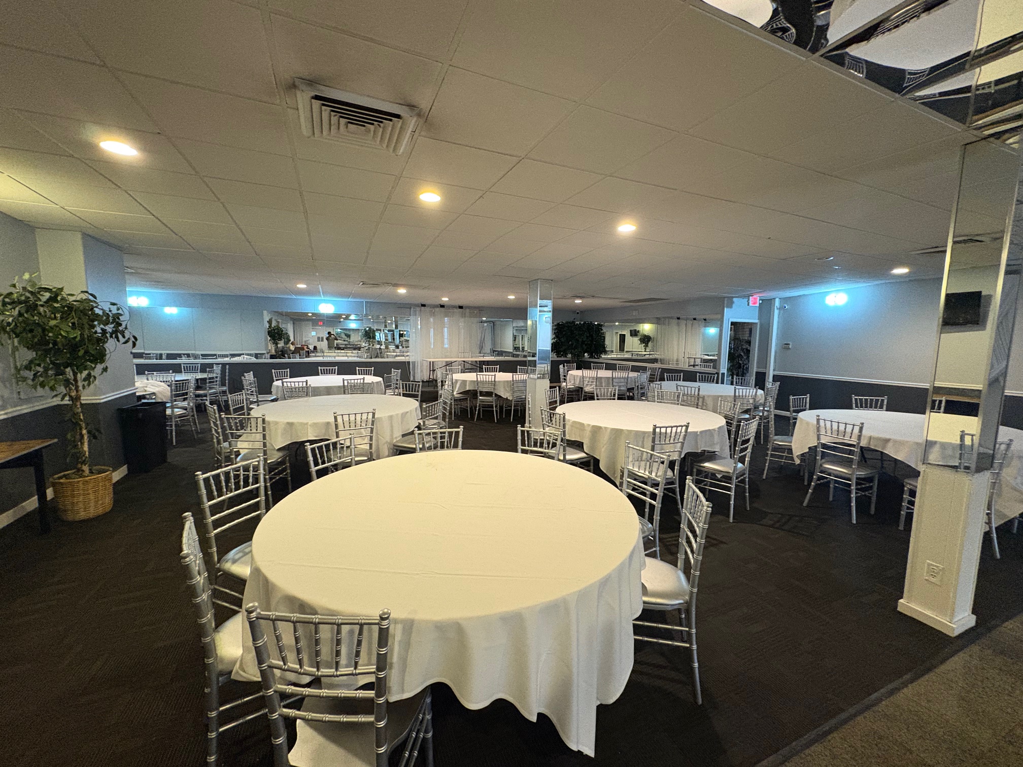 Banquet hall interior with round tables and silver chiavari chairs
