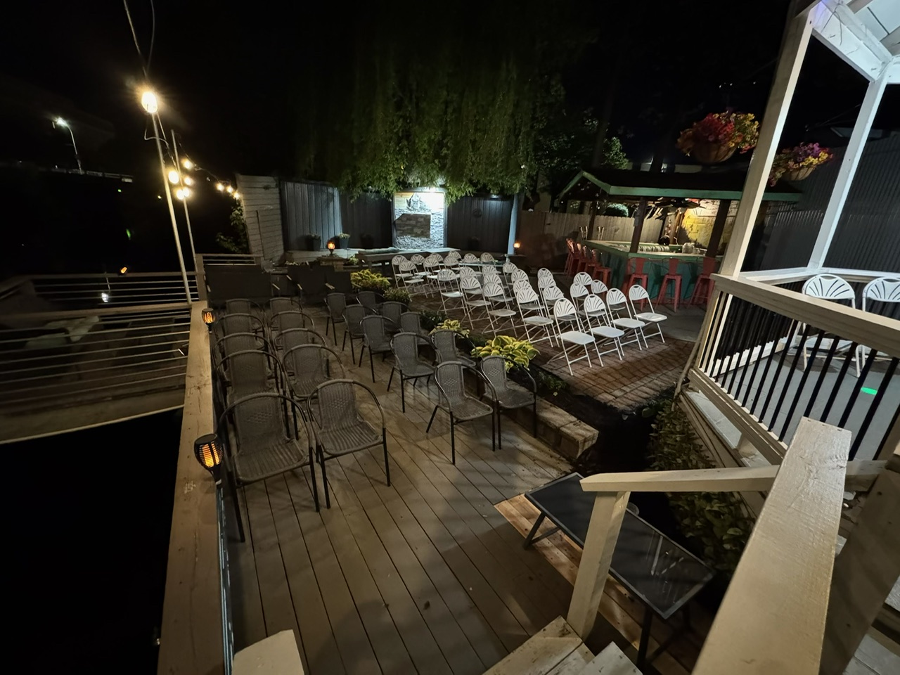 Outdoor ceremony space at night with string lights and seating